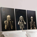 Three ivory skeleton posters displayed over a bed on dark backgrounds