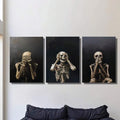 Gothic skeleton triptych hanging above a dark sofa on a pale wall