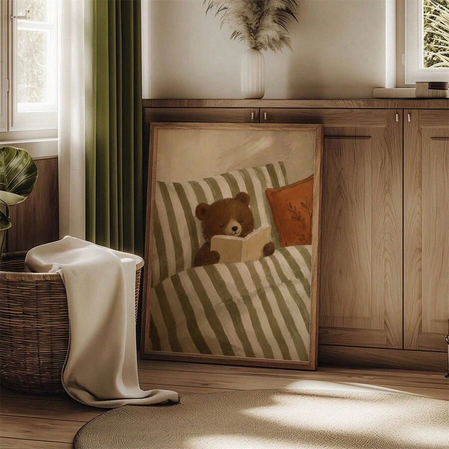 Framed reading bear artwork leaning against a pale nursery wall