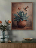 Framed agave and hummingbird print displayed above a console with flowers