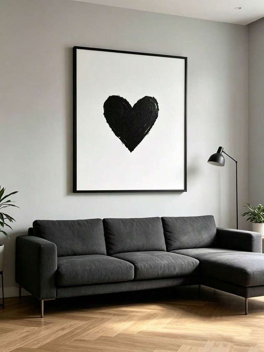 Framed black heart canvas centered above a charcoal sofa in a modern living room