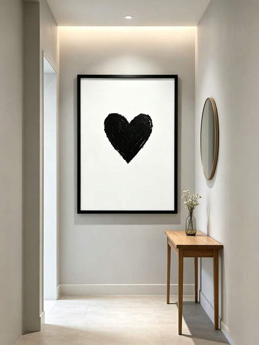Black heart wall art displayed above a narrow console in a bright entryway