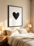 Framed black heart canvas displayed above a softly styled bedroom