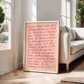 Uplifting pink typography canvas displayed beside neutral living room sofa