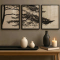 Black-framed beige pine branch triptych above a console with neutral ceramic vases