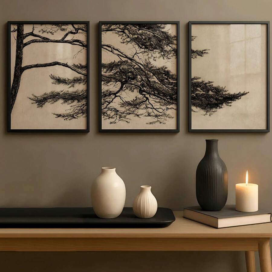 Black-framed beige pine branch triptych above a console with neutral ceramic vases