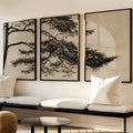 Botanical three-panel canvas in black frames above a light sofa in a neutral living room