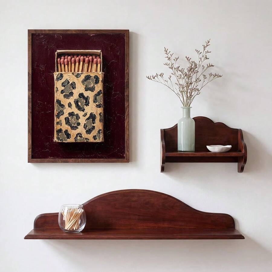 Framed leopard matchbox poster displayed above a vintage wood bench with a decorative vase