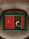 Retro red photo-booth artwork in a green frame against leopard upholstery