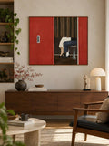 Wide framed figure artwork styled in a living room beside books and lamp
