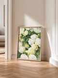 White and pale yellow hydrangea canvas in wood frame on bright herringbone floor