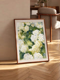 Watercolor hydrangea print leaning in a sunny living area with wood frame