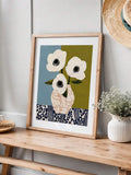 Botanical canvas poster on a wooden console beside a white vase