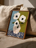 Framed anemone bouquet poster displayed on cream textured bedding