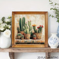 Framed cactus canvas displayed on a wooden console beside white flowers