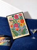 Bright botanical canvas leaning against a deep blue sofa