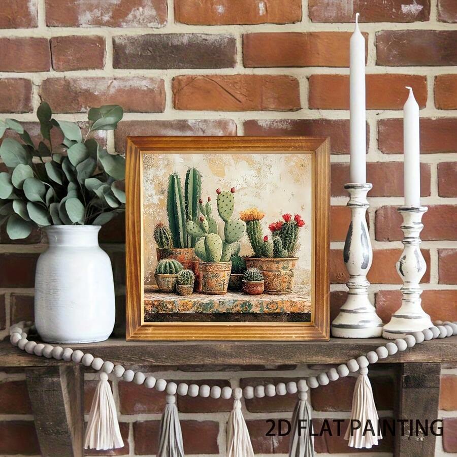 Small framed cactus artwork styled on a rustic shelf against brick with candles