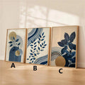 Three coordinated navy botanical panels labeled A B and C leaning against a warm neutral wall