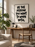 Minimalist black lettering canvas displayed over a wooden desk and chair