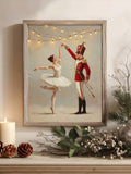 Framed ballerina and red nutcracker dancing beneath warm lights on a decorated mantel