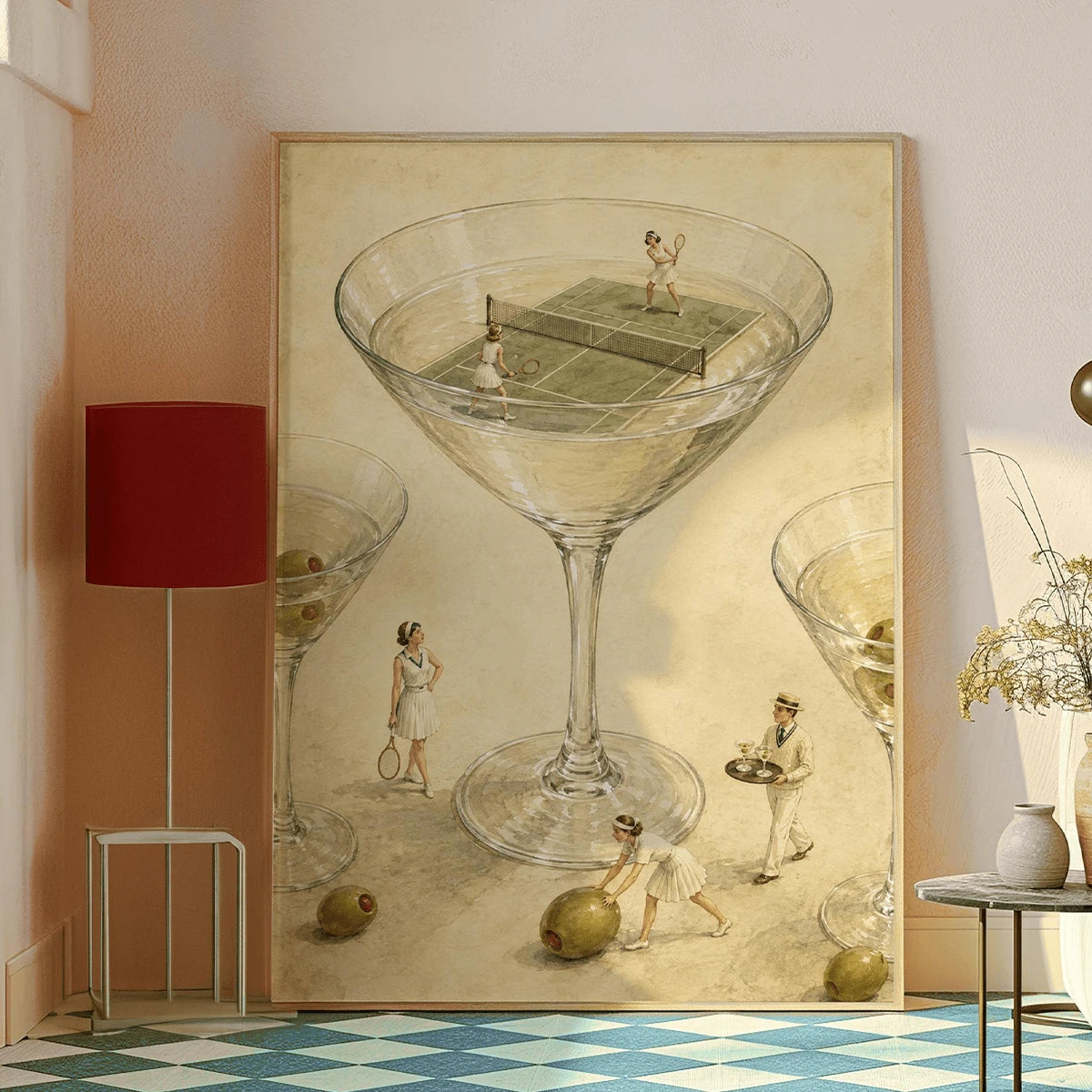 Framed martini glass tennis artwork displayed against a warm neutral wall beside a red lamp