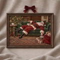Close view of sleeping Santa artwork in a dark wood frame with a red bow