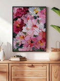 Pink and cream peony botanical poster displayed in a gold frame beside a dresser and natural decor