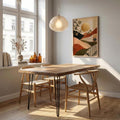 Olive branch geometric canvas poster in a bright dining room with wooden table and woven chairs