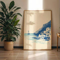 Blue seaside village canvas print displayed beside a leafy plant in a sunlit living room