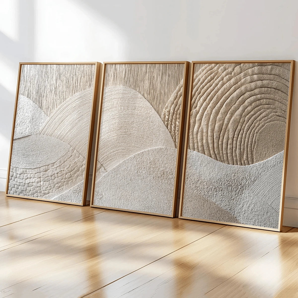 Close view of beige and cream abstract triptych canvases in slim wood frames