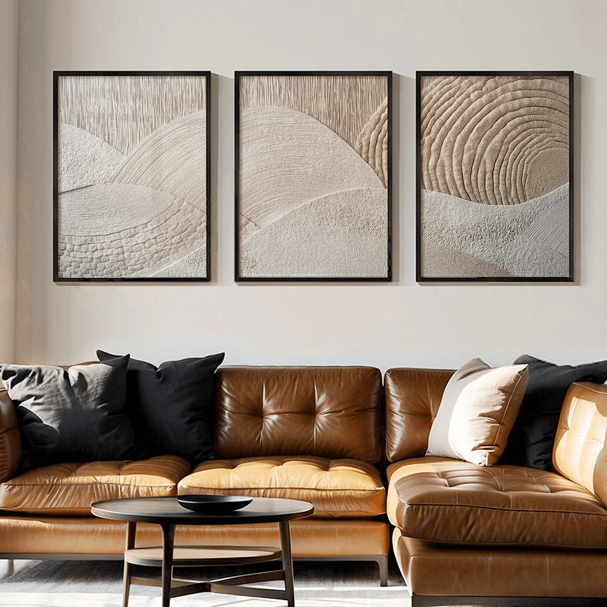 Three-panel neutral wall art displayed above a brown leather sofa