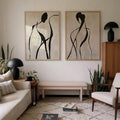 Pair abstract black figure line art prints above bench in warm modern living room