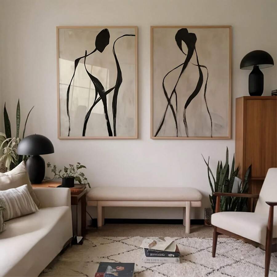 Pair abstract black figure line art prints above bench in warm modern living room