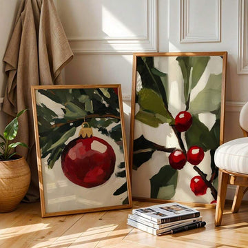 Two framed holiday canvases show a red bauble and holly berries among dark green leaves