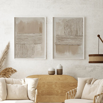 Two cream and beige ribbed abstract canvases above pale sofa and wood sideboard