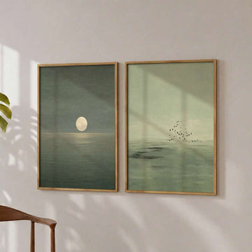 Two sage green ocean prints: full moon over water and birds above a misty sea
