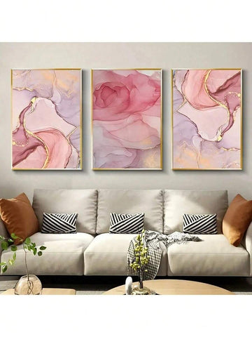 Three pink marble abstract canvas prints with gold accents above beige sofa