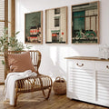 Three framed Japanese street-scene prints above a rattan chair and white cabinet