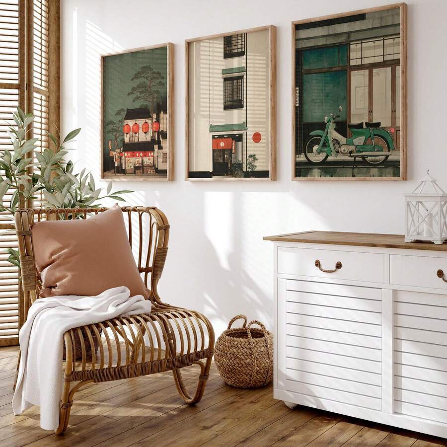 Three framed Japanese street-scene prints above a rattan chair and white cabinet