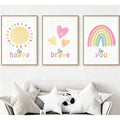 Three-piece kids wall art above sofa with Be happy sun, Be brave hearts and Be you pastel rainbow