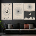 Three celestial prints with orbital crescent, radiating sunbursts, and forest night scene above a dark sofa