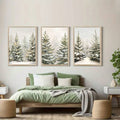 Three framed snowy pine landscape panels arranged above a sage green bed
