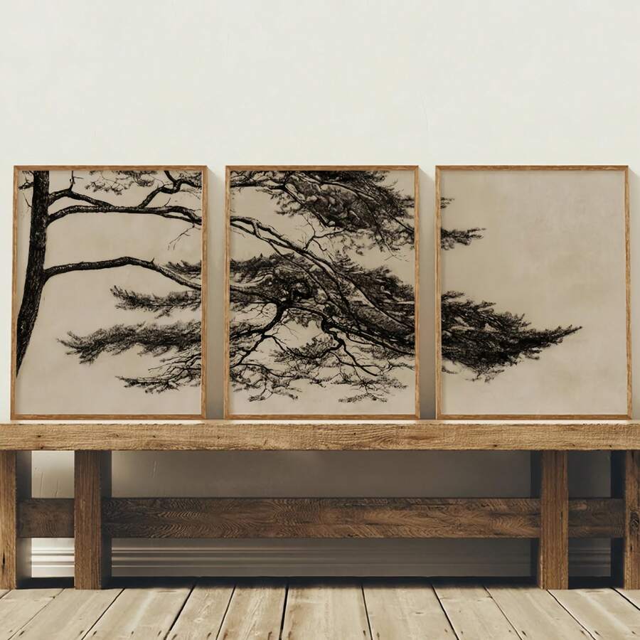 Three-piece pine branch canvas triptych in black ink on beige, displayed above a wood console