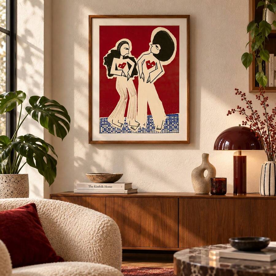 Framed two-women fashion illustration poster above a wooden sideboard in a bright room