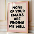 Gold frame mockup of pink retro email humor poster against a white paneled wall