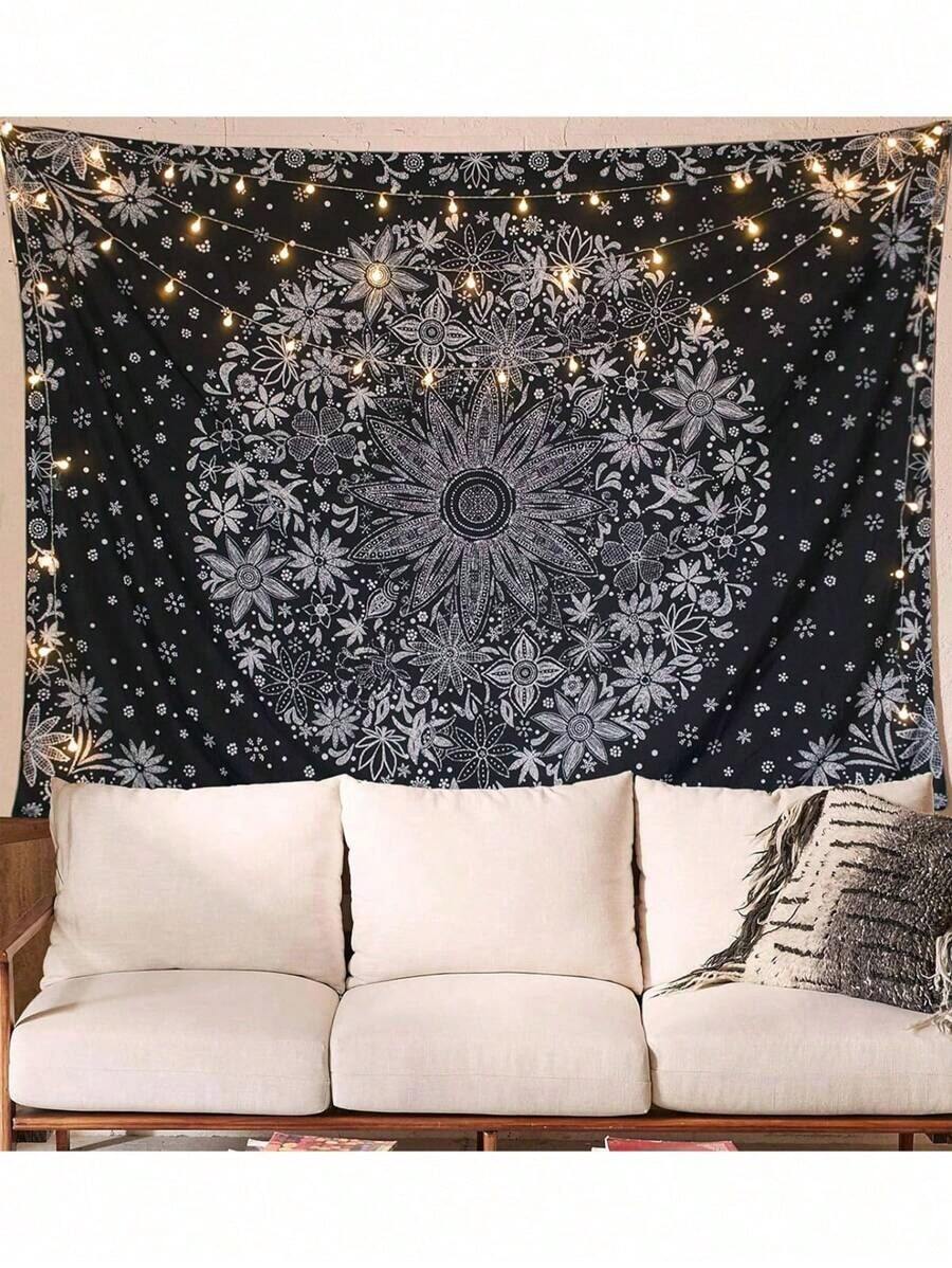 Black and white mandala tapestry displayed above sofa with string lights