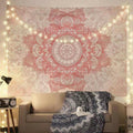Pink mandala tapestry hanging above beige sofa with fairy lights and boho throw blanket