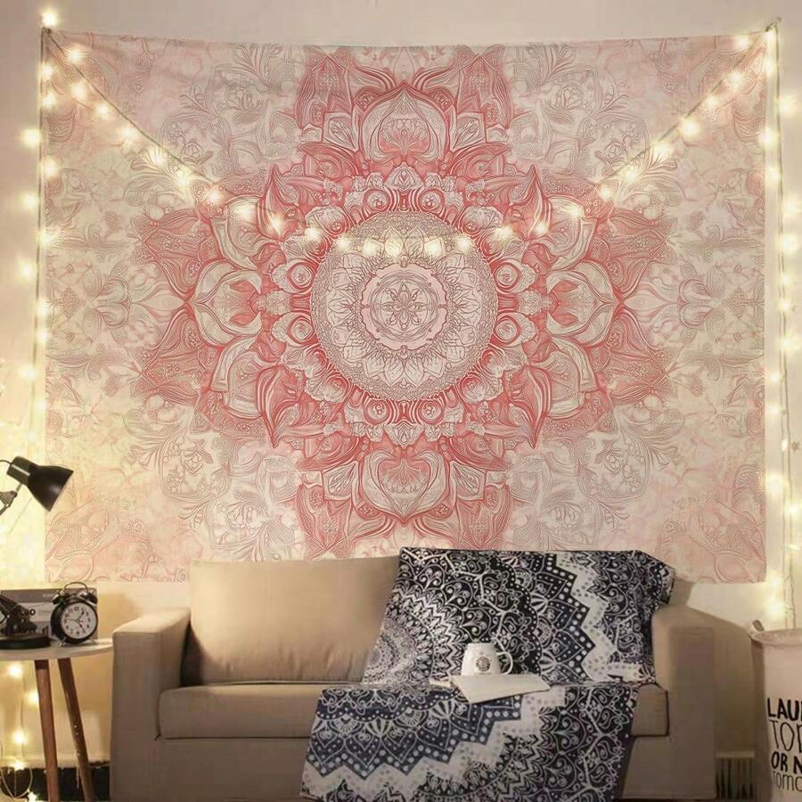 Pink mandala tapestry hanging above beige sofa with fairy lights and boho throw blanket