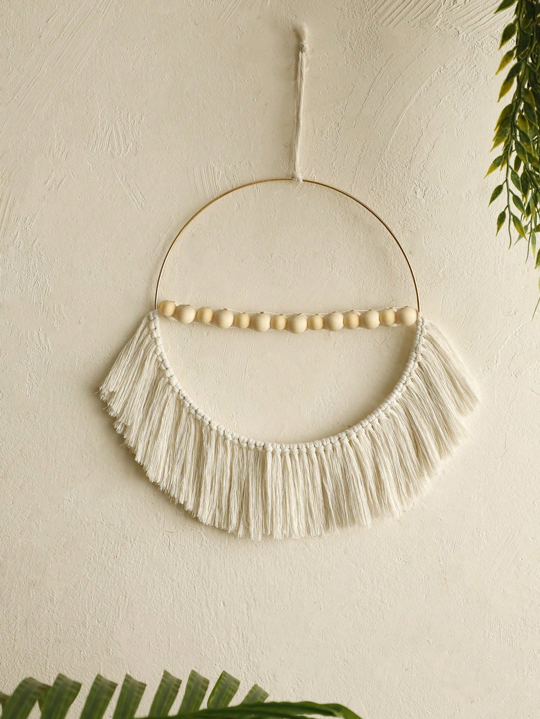 This bohemian wood bead fringe wall pendant is a chic and decorative accent for any home or bedroom. Its unique design adds a touch of style to any room, making it a perfect statement piece. Handcrafted with quality materials, this pendant is sure to elevate the aesthetics of any space.
