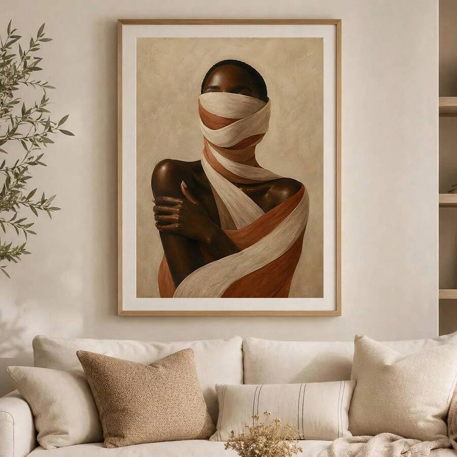 Framed portrait of woman wrapped in cream and terracotta fabric above beige sofa with neutral pillows